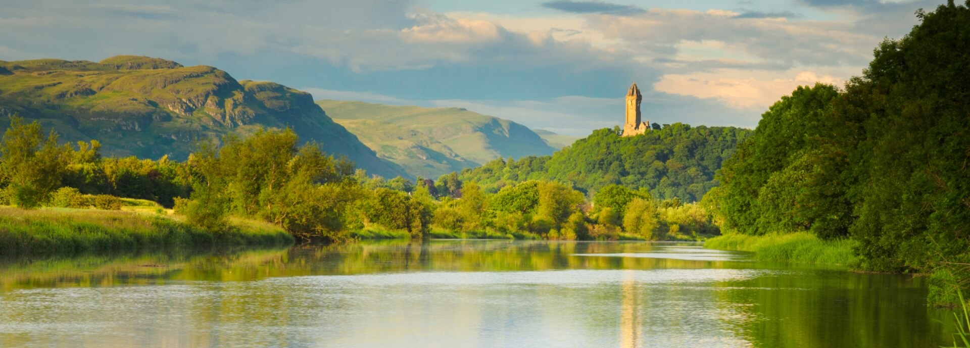 river with monument on hill